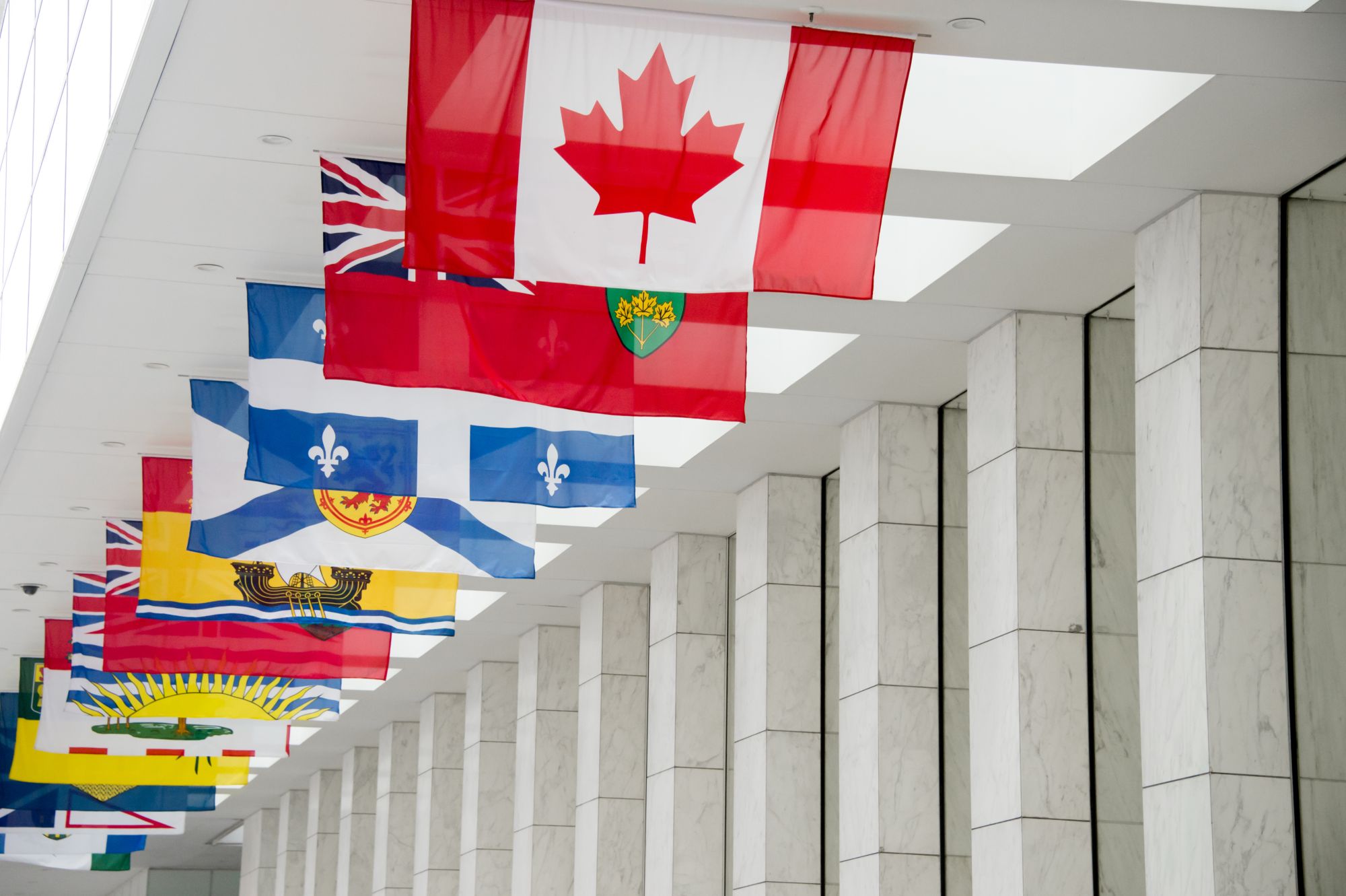 The Canadian flag beside the flags of the ten provinces and three territories in Toronto