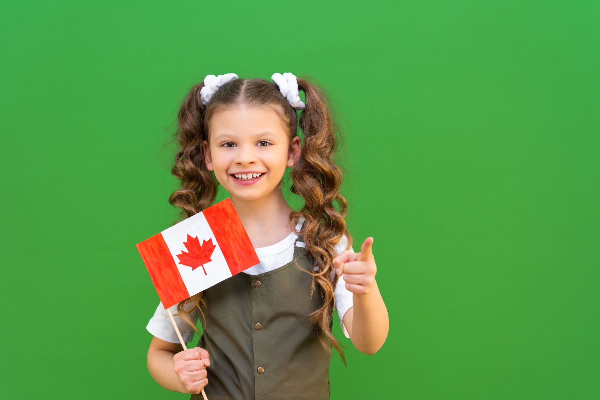 A schoolgirl holding the Canadian flag and pointing ahead